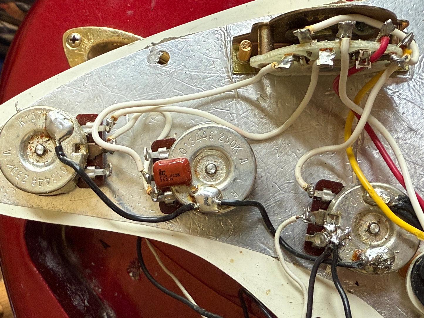 Close-up of a guitar pickup and wiring harness with visible components.