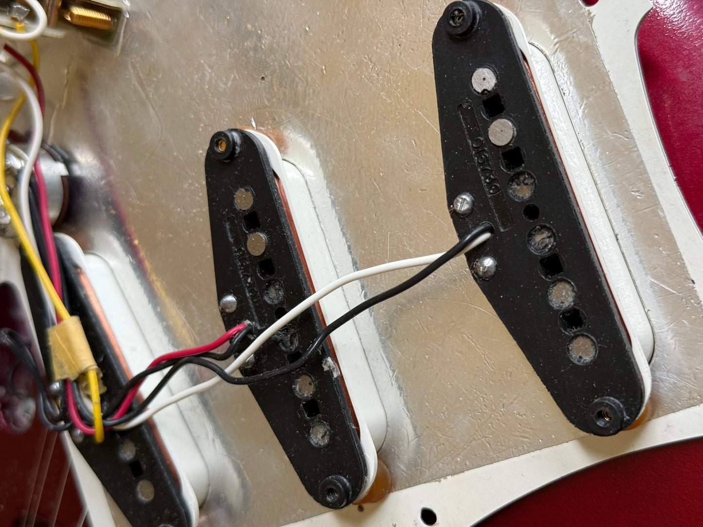 Close-up of guitar pickups with wiring on a metallic surface