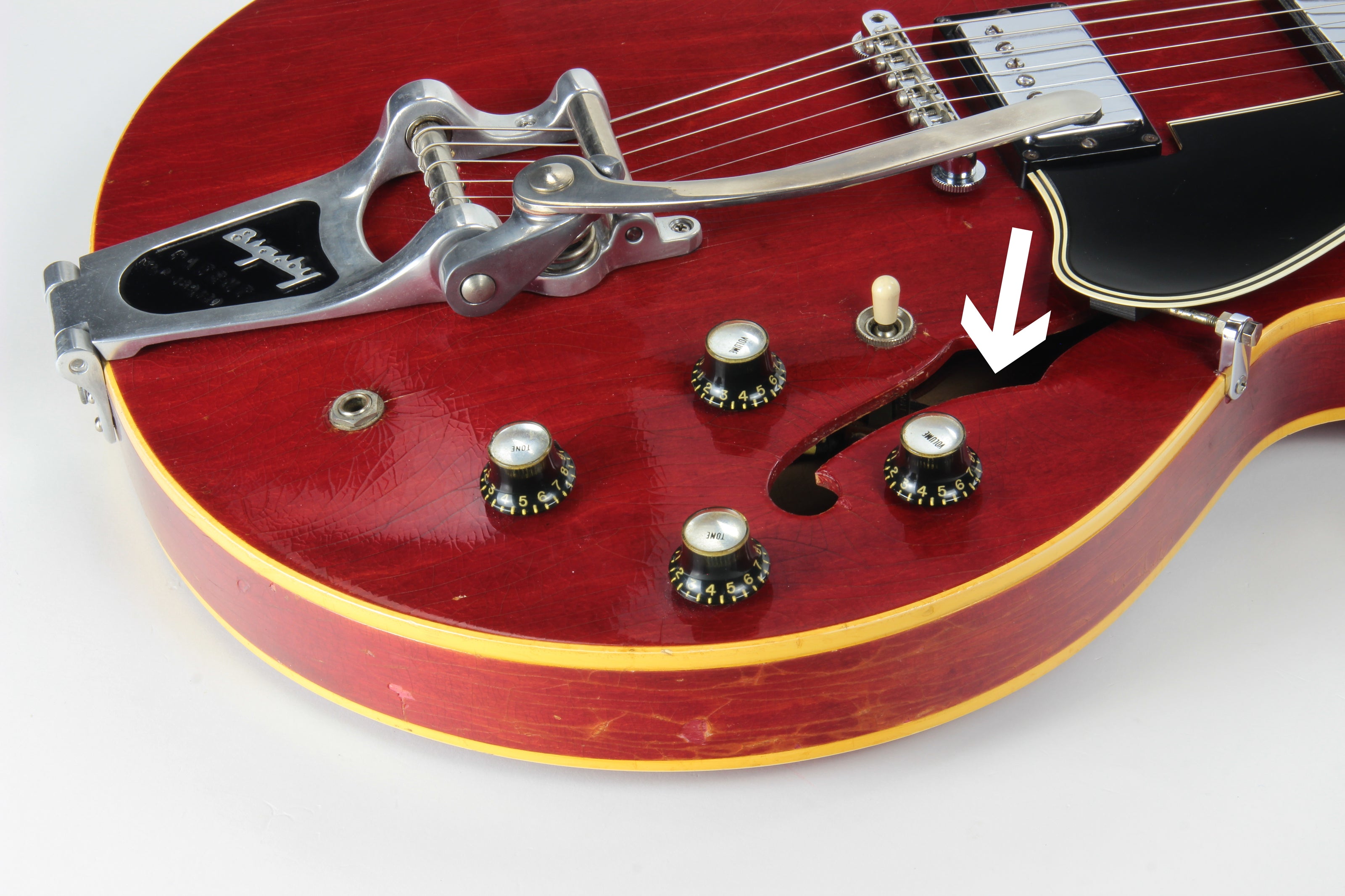 1960's Gibson ES-335 with arrow pointing to treble f-hole